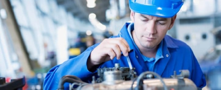 A maintenance technician is repairing an engine