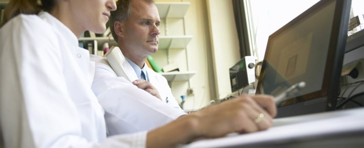 man-and-woman-in-lab-coats-looking-at-a-computer-suggests-considering-how-long-a-career-change-to-pharmaceutical-manufacturing-will-take