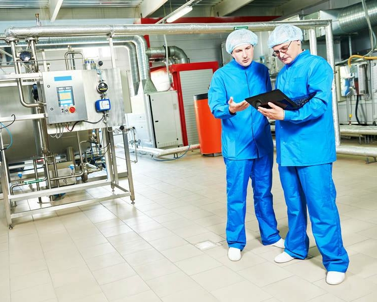 production-supervisor-and-staff-member-in-personal-protective-equipment-in-pharmaceutical-manufacturing-facility