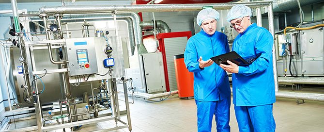 production-supervisor-and-staff-member-in-personal-protective-equipment-in-pharmaceutical-manufacturing-facility
