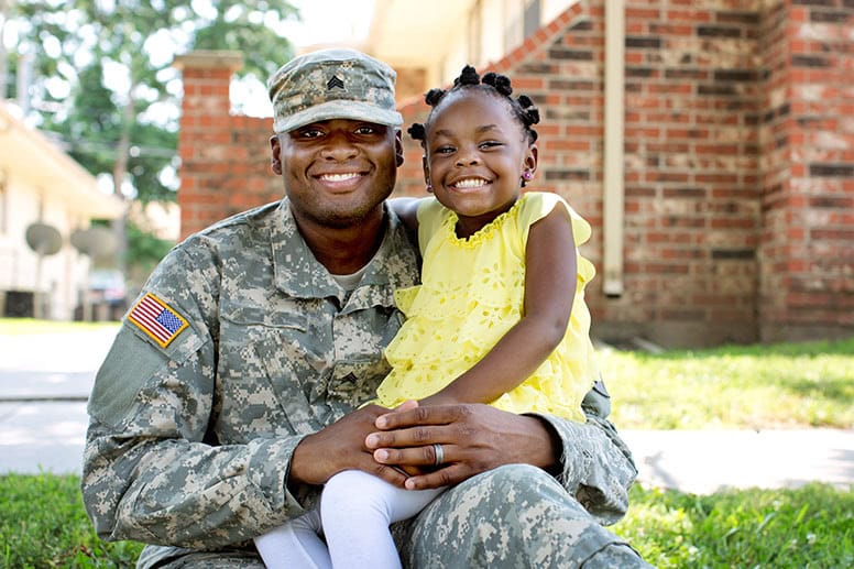 veteran-in-uniform-and-young-girl-smiling-at-camera