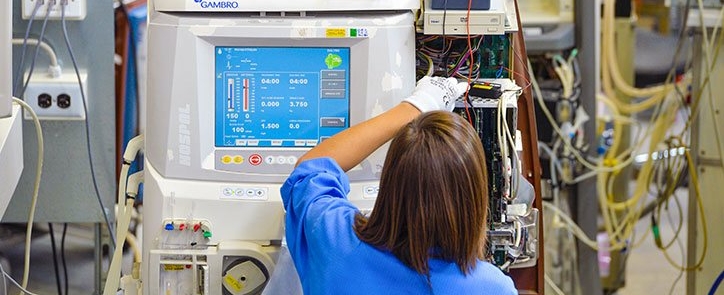 Manufacturing Technician assembles a piece of medical device equipment in a factory in Italy