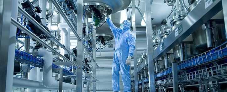 man in protective clothing operating manufacturing equipment