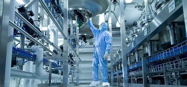 man in protective clothing operating manufacturing equipment