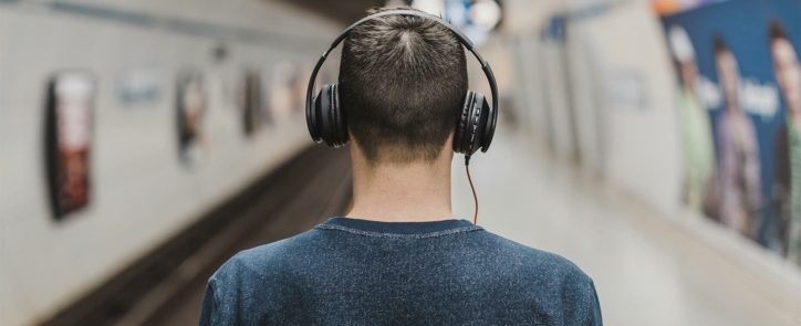 Man wearing headphones listening to the best pharma and medtech podcasts