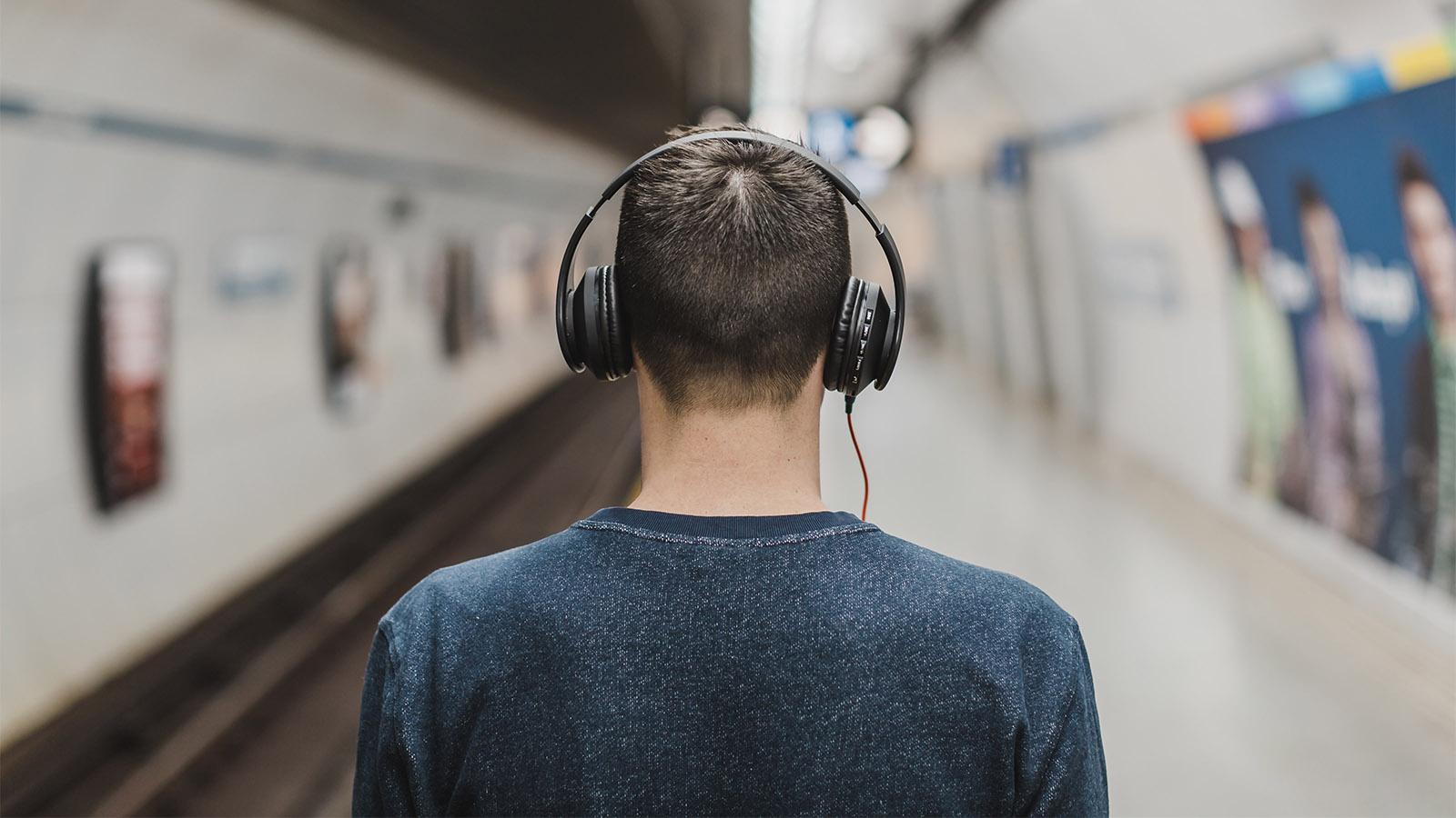 Man wearing headphones listening to the best pharma and medtech podcasts