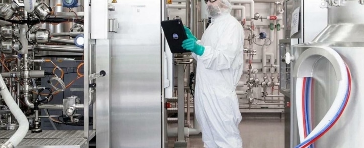 man with machinery looking at tablet