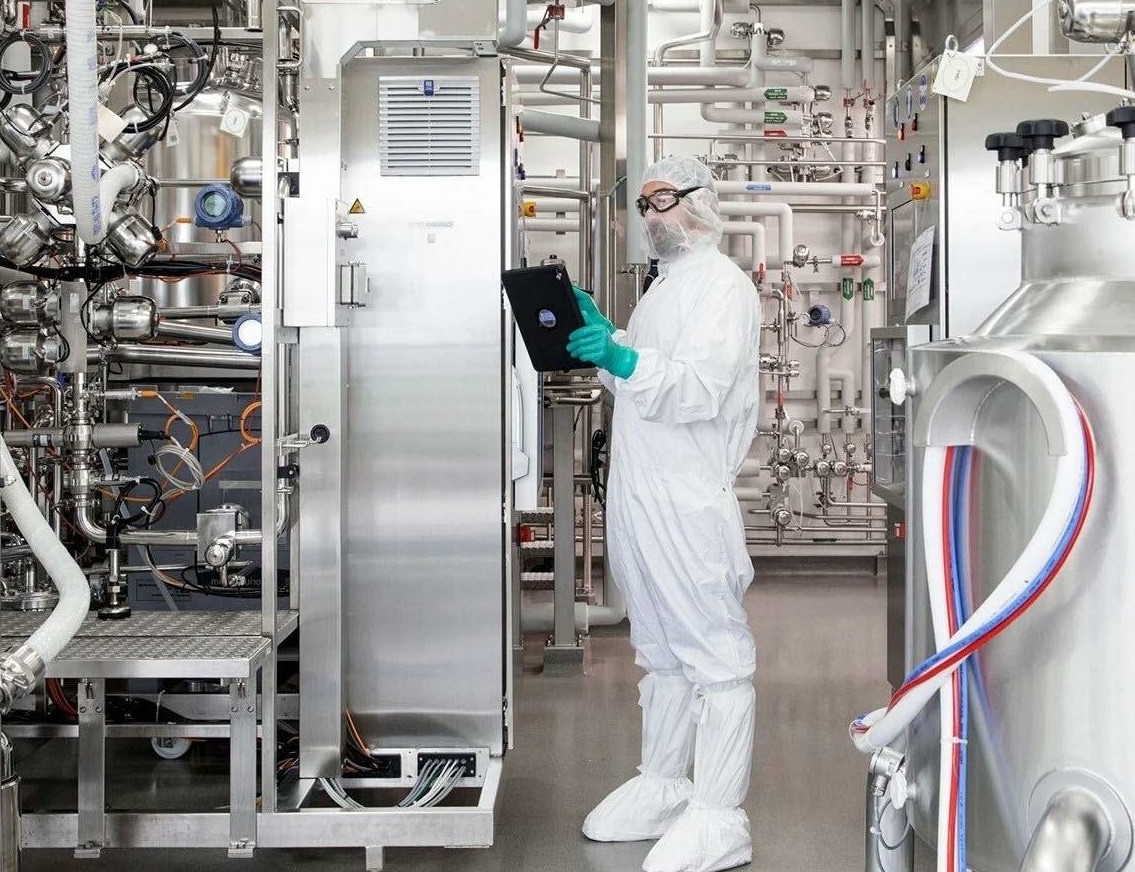 man with machinery looking at tablet